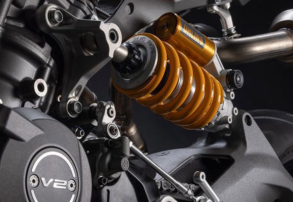 Suspensi belakang Öhlins pada Ducati Panigale V2 Special Edition MM93 menggunakan dudukan atas yang terhubung ke kepala silinder mesin V2. Konstruksi ini menjadi bagian dari desain motor yang mengutamakan efisiensi rangka, bobot ringan, serta performa pengendalian. Foto: Ducati/GridOto.com